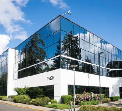 Contemporary office building in Redmond with reflective glass and lush greenery, captured on a sunny day.